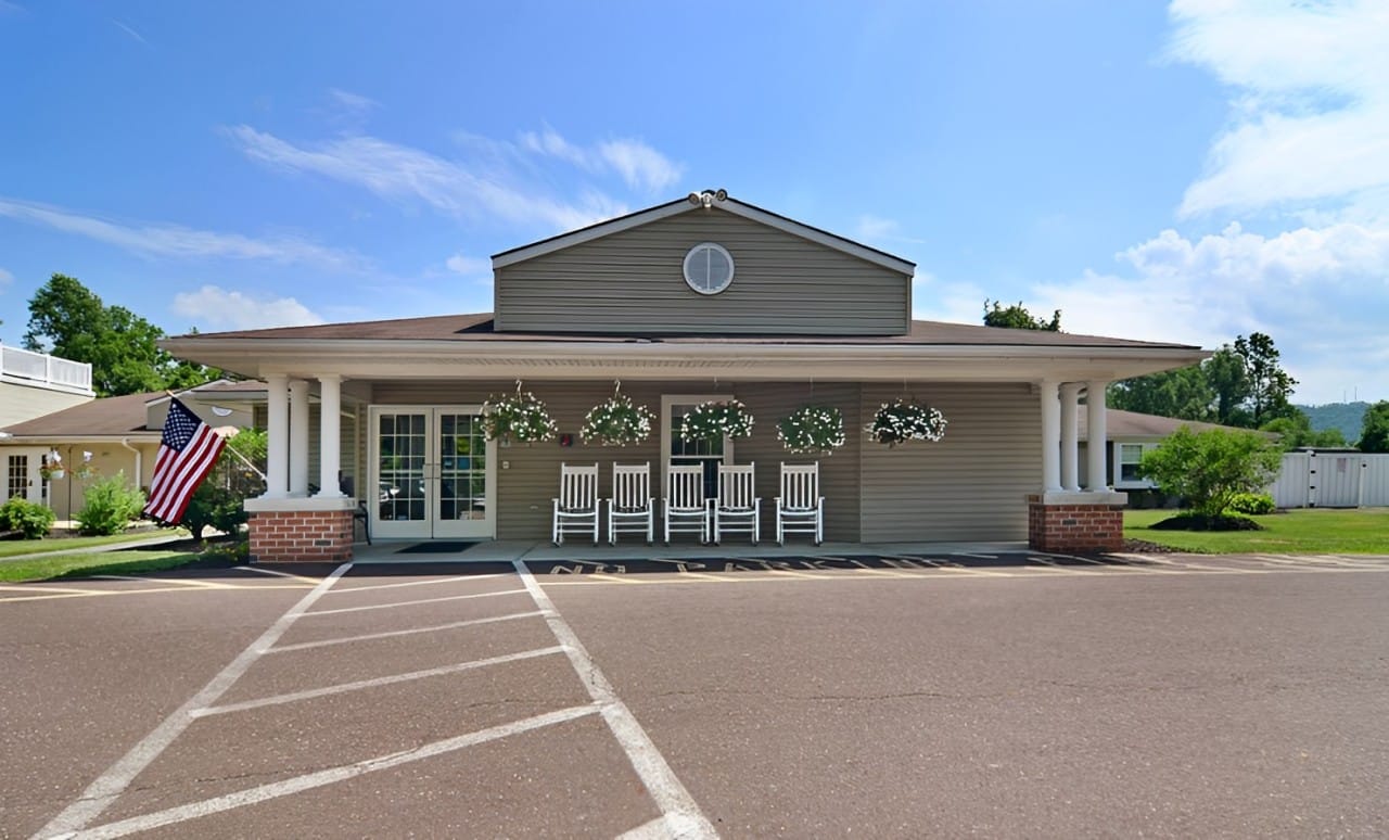 Front exterior of a senior living facility with rocking chairs