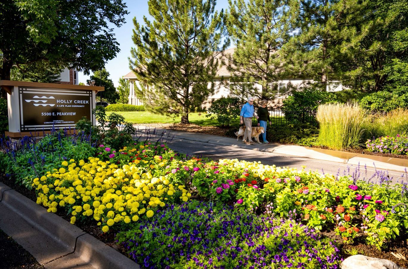 Residents enjoying a walk surrounded by colorful flowers