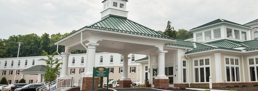 Exterior view of a senior living facility with a covered entrance