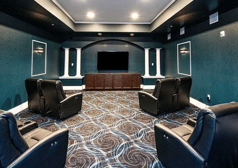 Spacious theater room with recliner chairs and a large screen TV