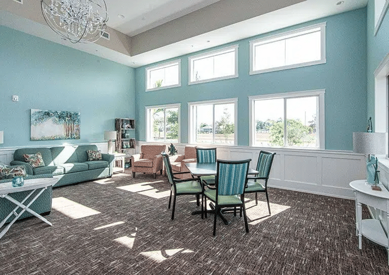 Spacious living room with large windows and comfortable seating in Hampton Manor.