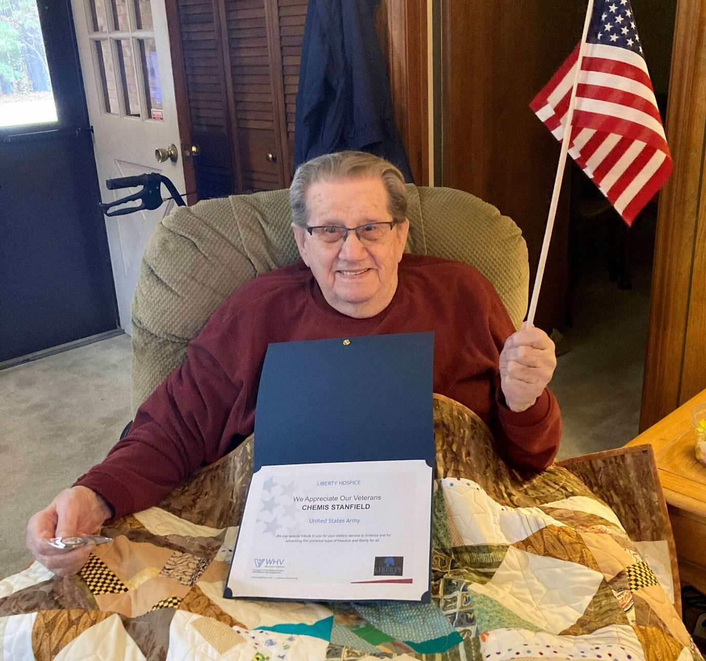 Senior holding a certificate and American flag.