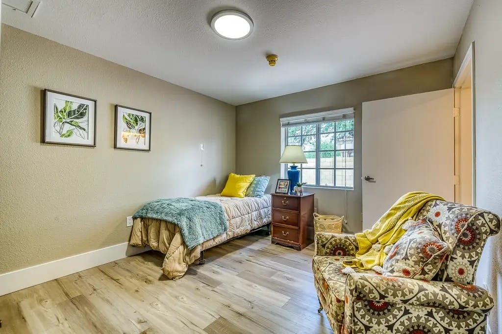 Cozy resident room with a bed and armchair