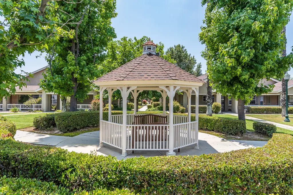 Outdoor gazebo surrounded by greenery in a senior living community