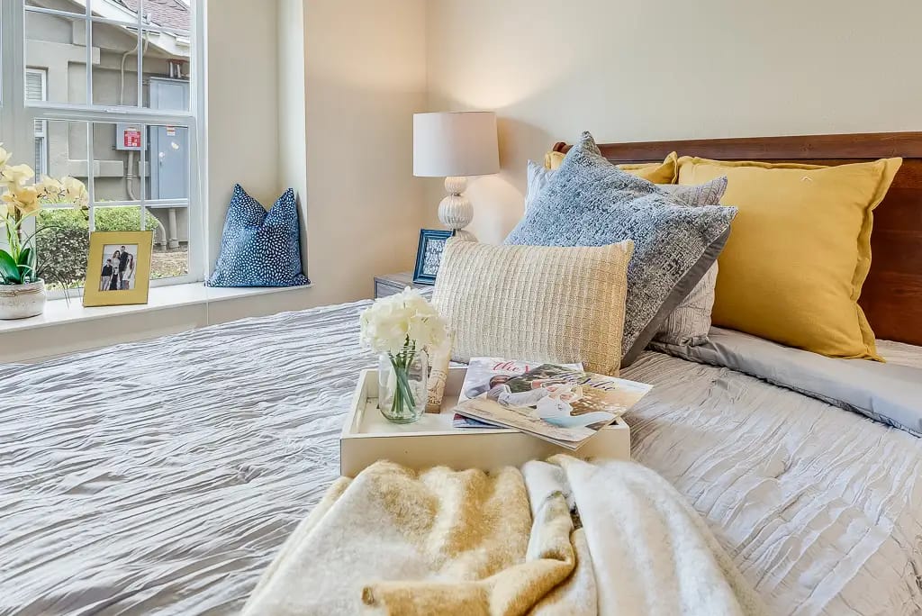 Cozy bedroom setup with decorative pillows and a lamp