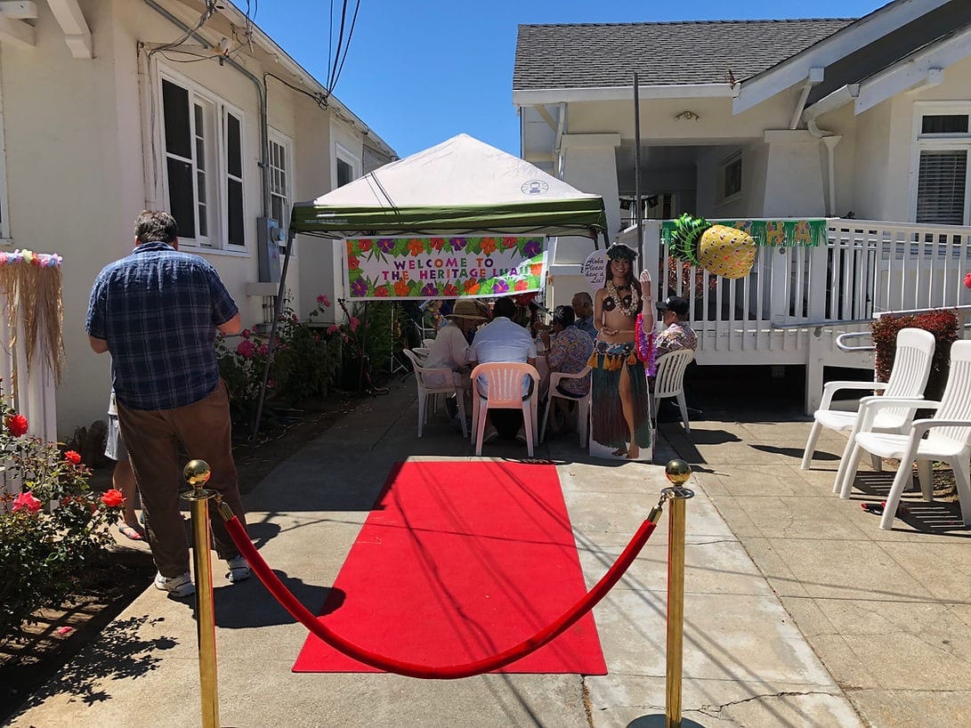 Outdoor welcome event with decorated tent and red carpet.