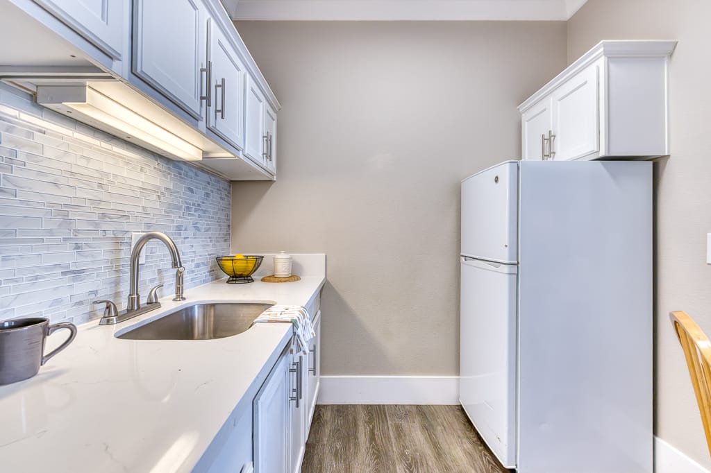 A modern kitchen area with appliances and cabinetry