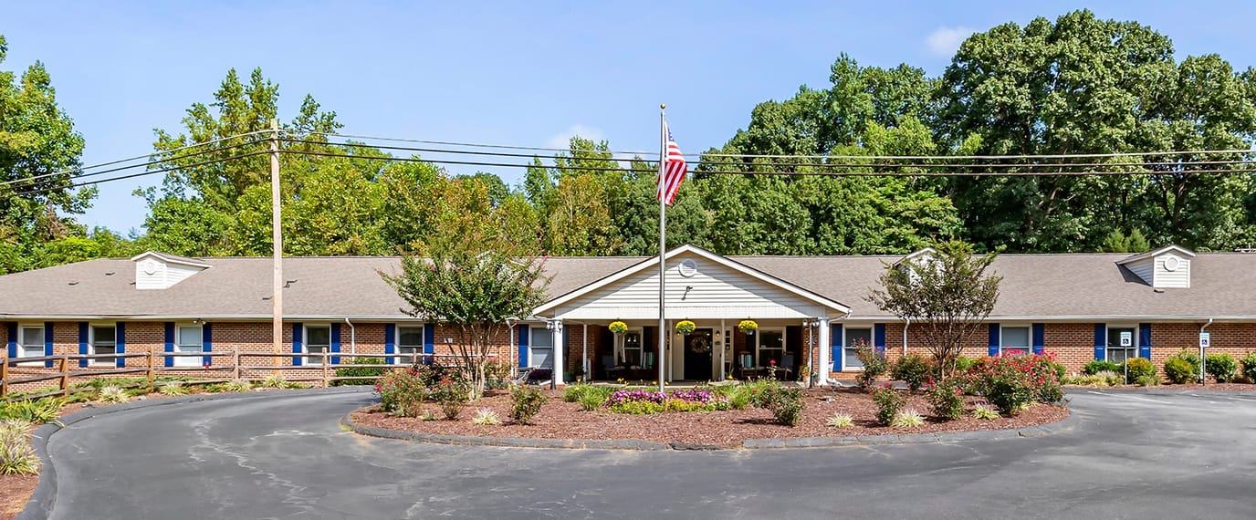 Exterior view of a senior living facility surrounded by greenery