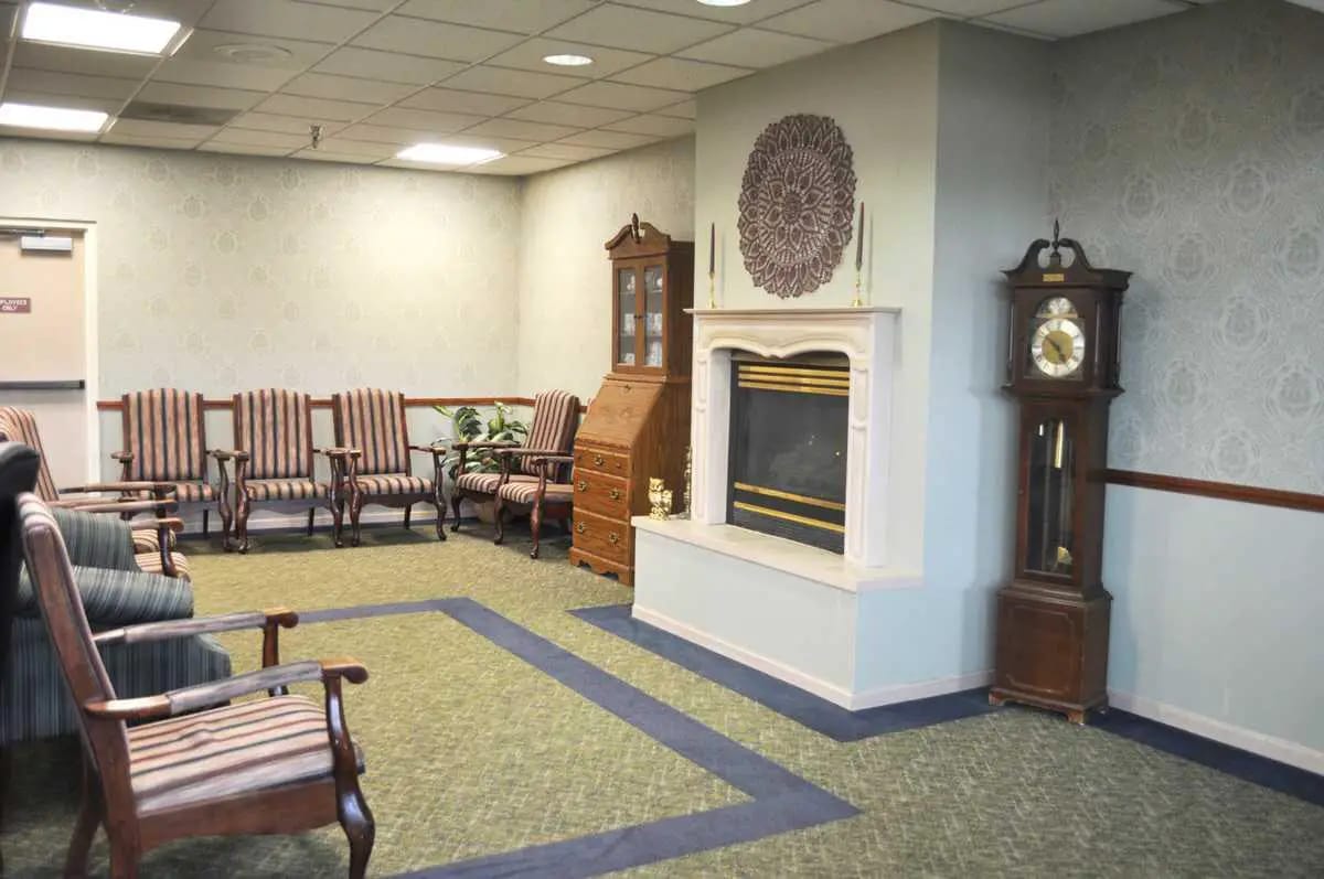 A spacious living room with striped chairs and a fireplace.