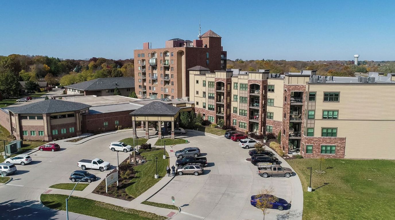 Aerial view of a senior living facility with parking and landscaped areas.