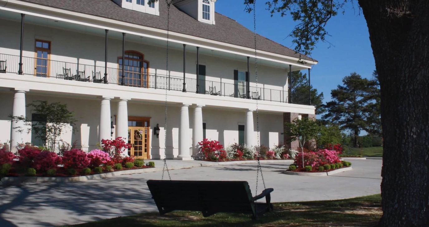 Exterior view of a nursing home with flowers and a swing.