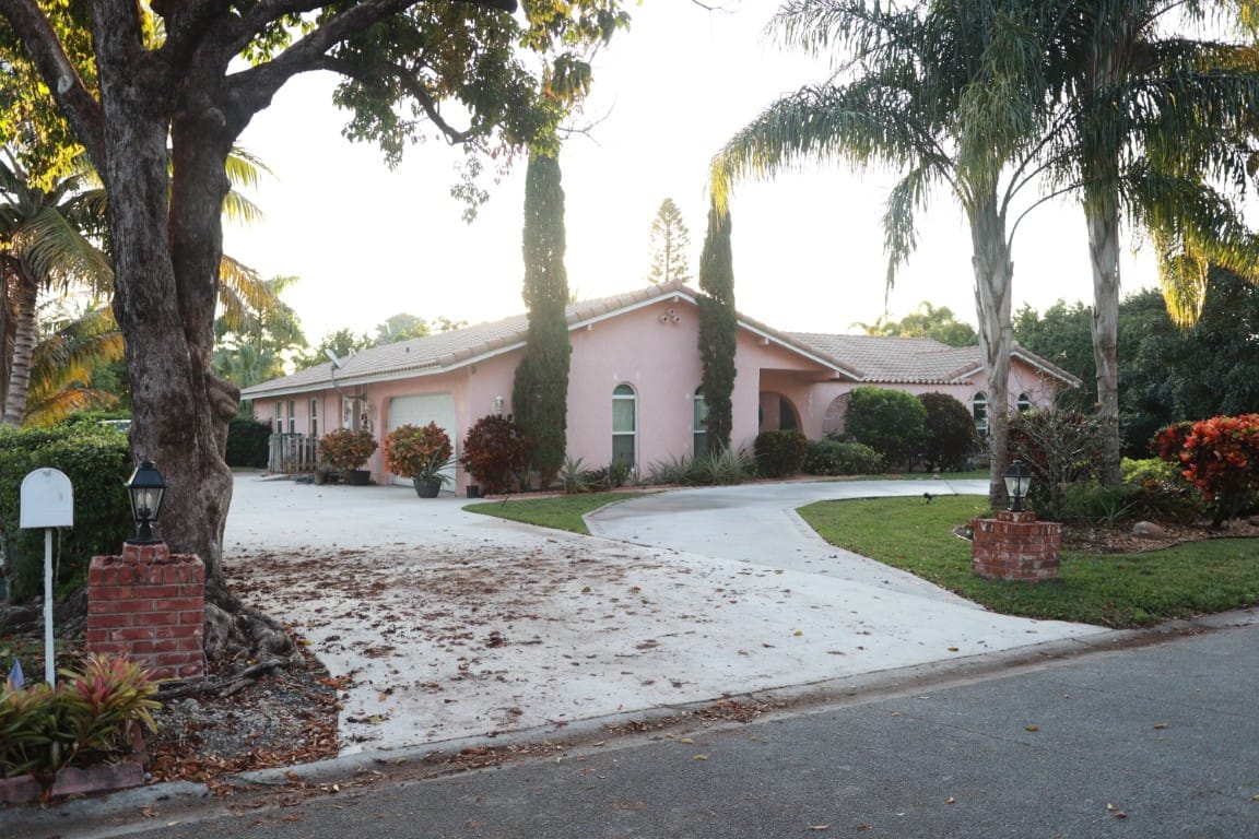 Exterior view of a pink building surrounded by greenery