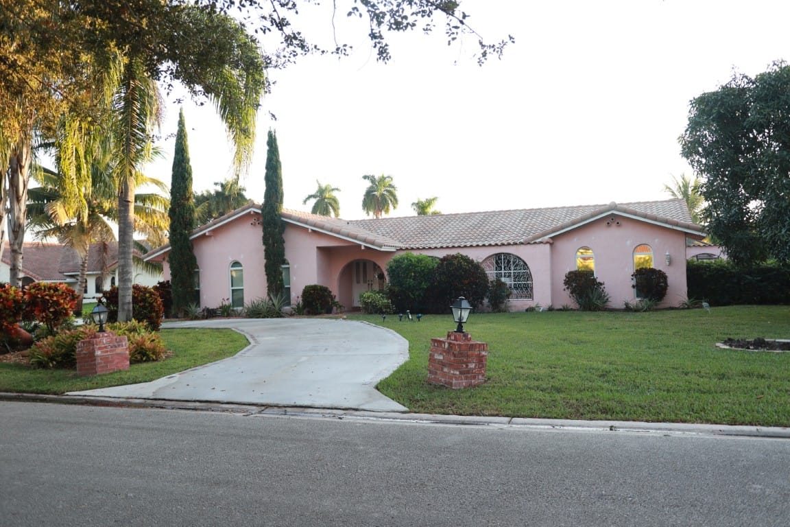 Exterior view of a single-story pink building with landscaping