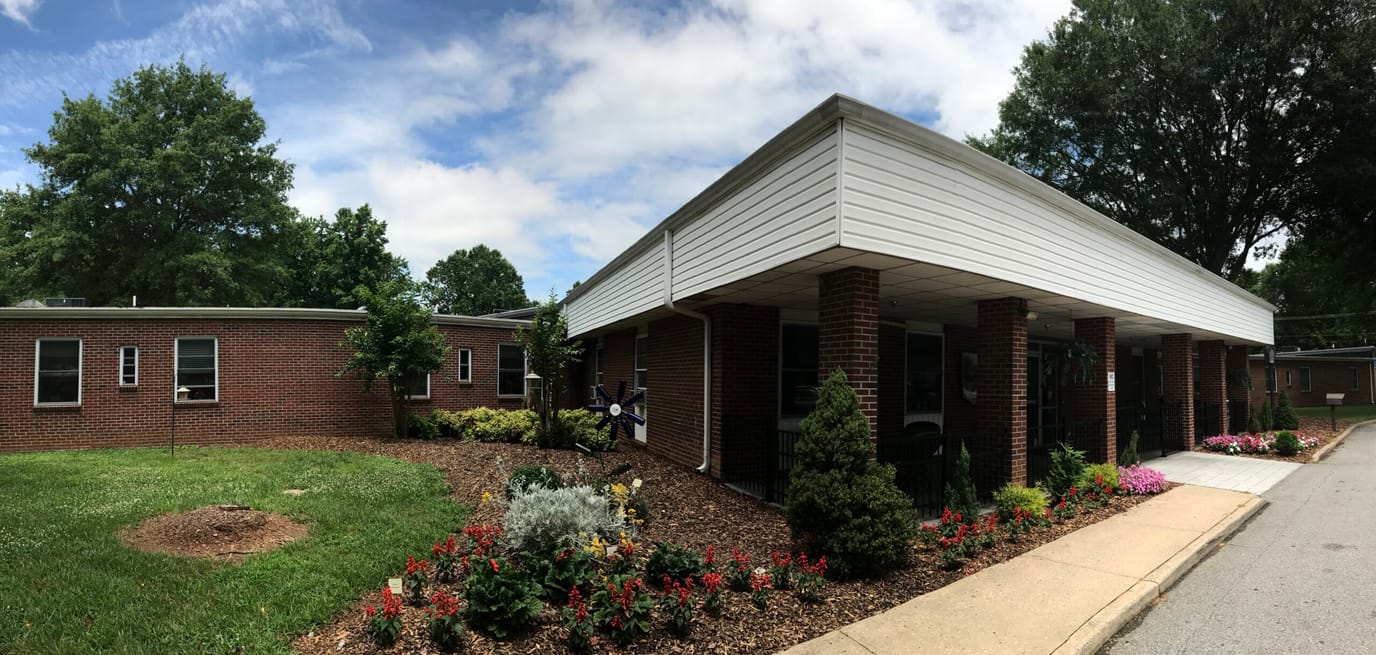 Exterior view of a senior living facility with gardens
