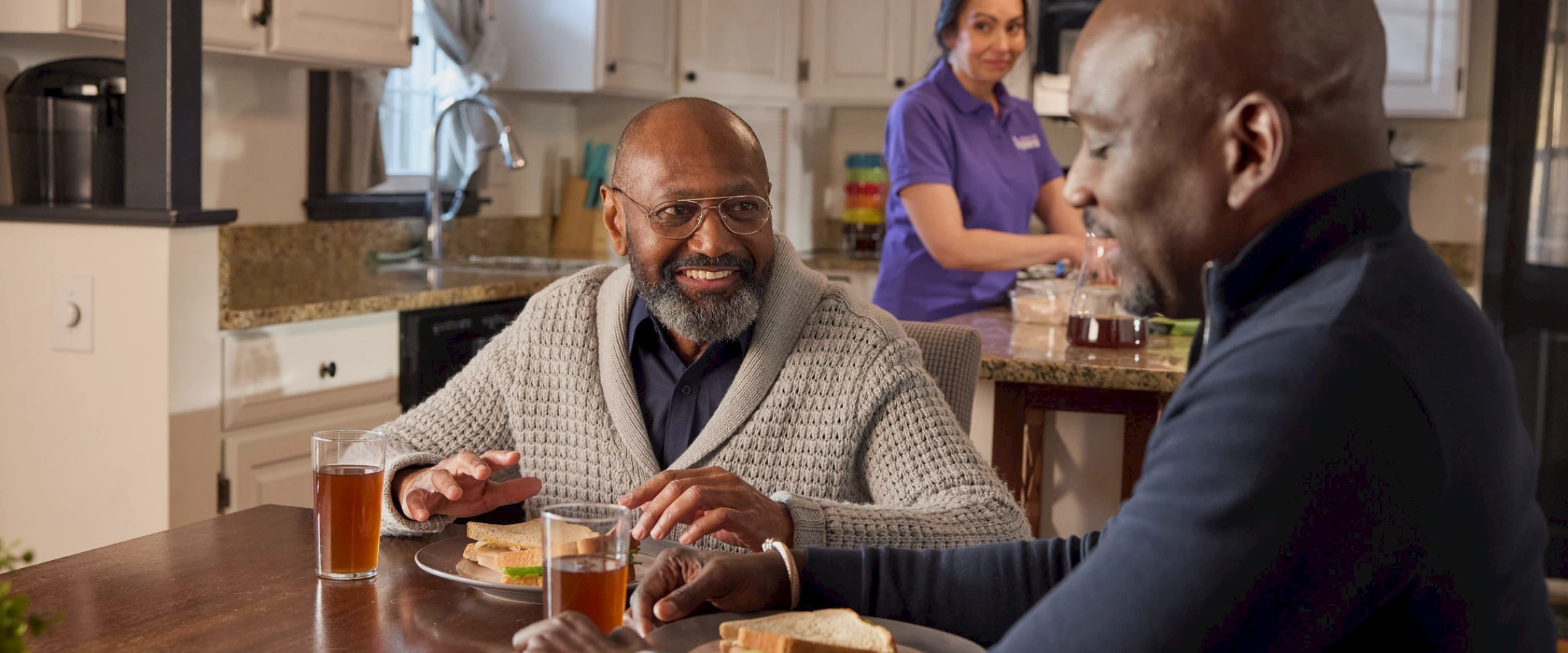 Residents enjoying lunch with a caregiver