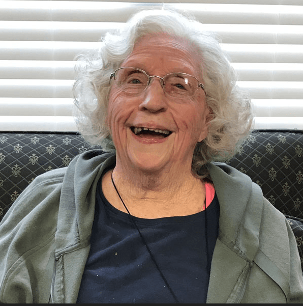 Smiling senior woman sitting in a common area.