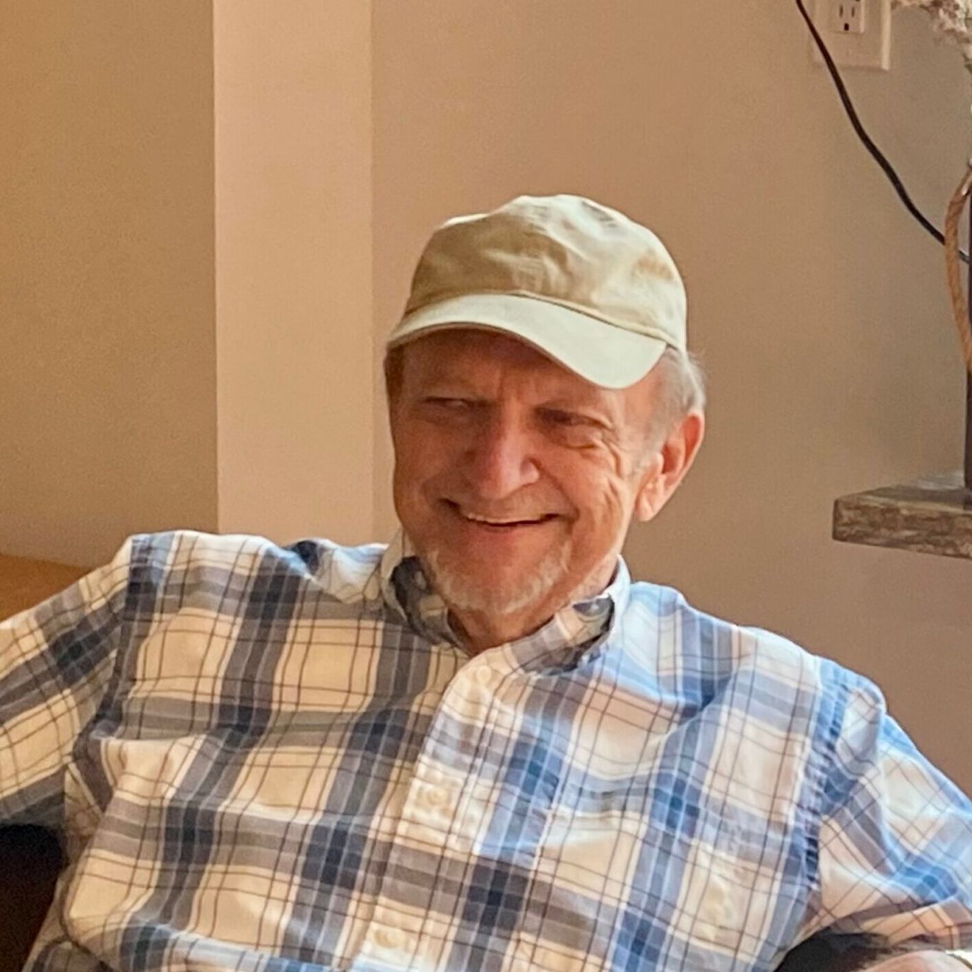 Smiling elderly man wearing a cap indoors