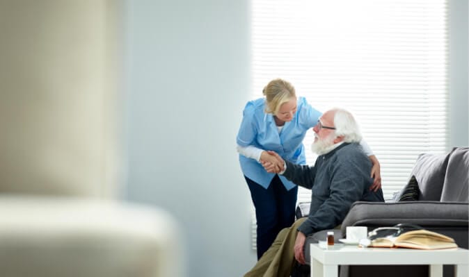 Caregiver interacting with a resident in a cozy interior.