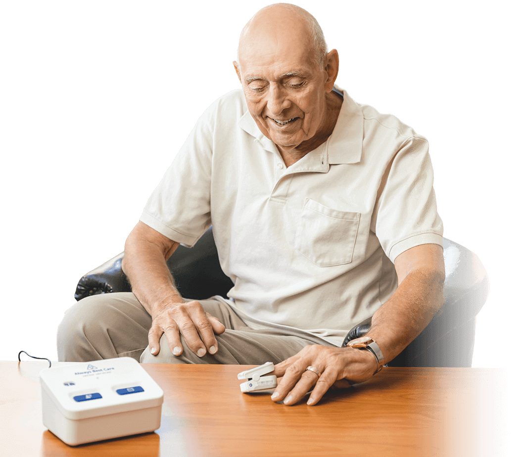 Senior man using a health monitoring device at a table
