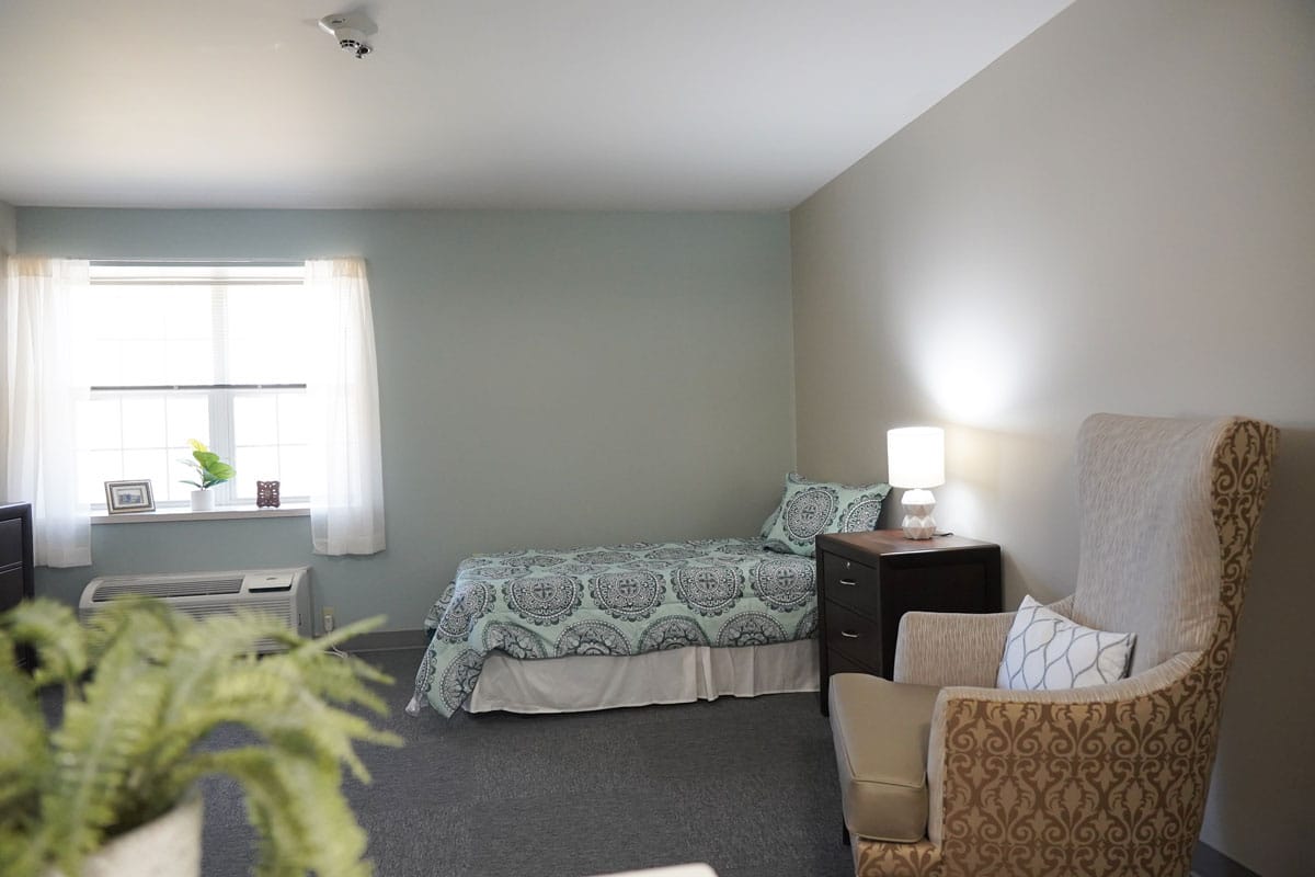 Private resident room with bed and chair