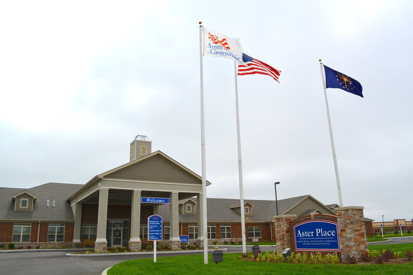 Exterior view of Aster Place facility with flags