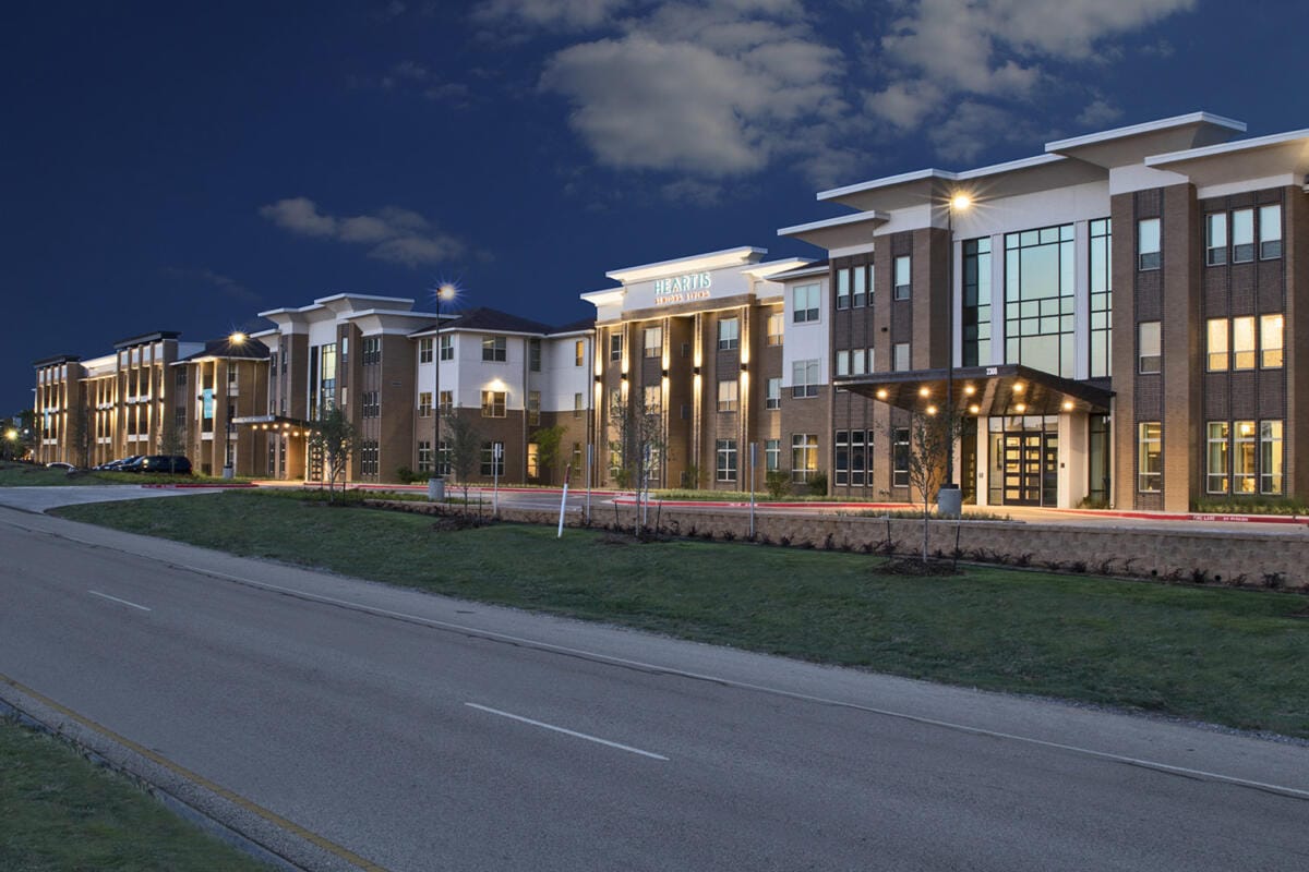 Exterior view of Heartis MidCities Assisted Living facility at dusk
