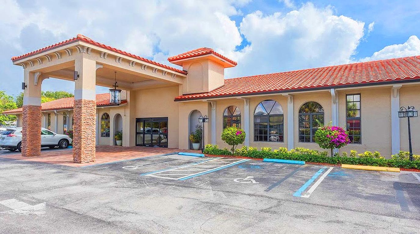 Exterior view of the assisted living facility with gardens