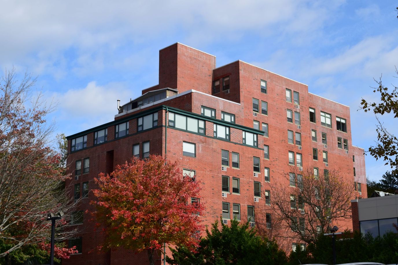 Exterior view of RiverWalk Senior Apartments with autumn foliage