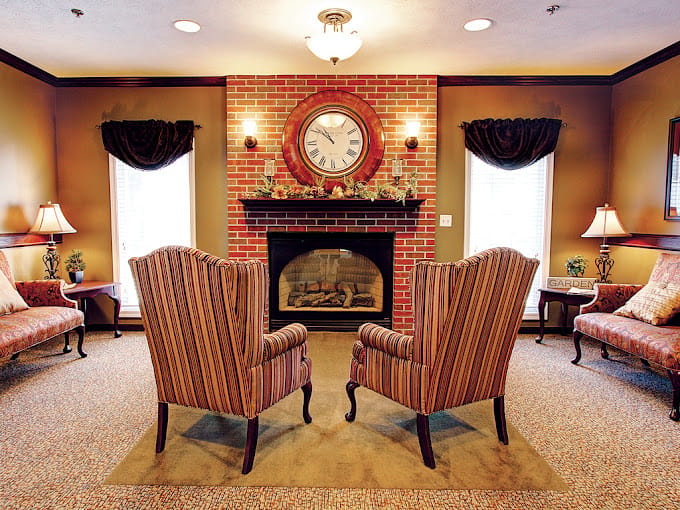 Striped armchairs facing a fireplace in a warm living room.