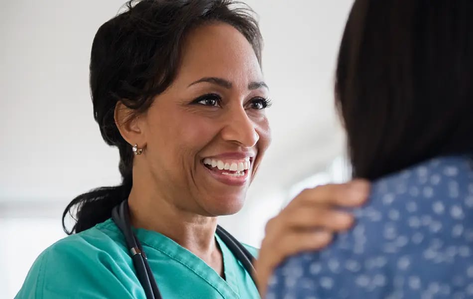 A healthcare worker smiling at a resident