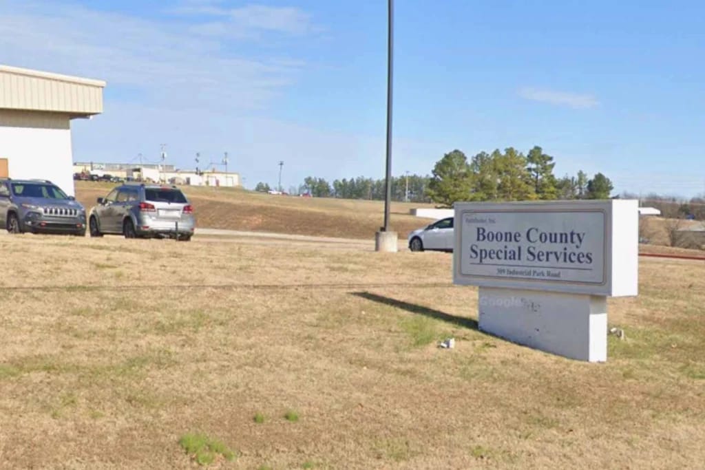 Exterior view of a facility sign and parking area