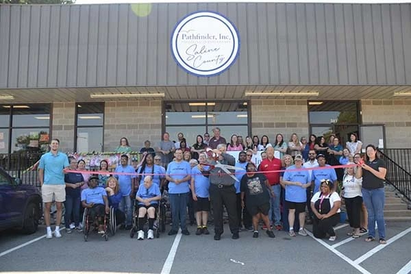 Grand opening ceremony with staff and residents outside the facility