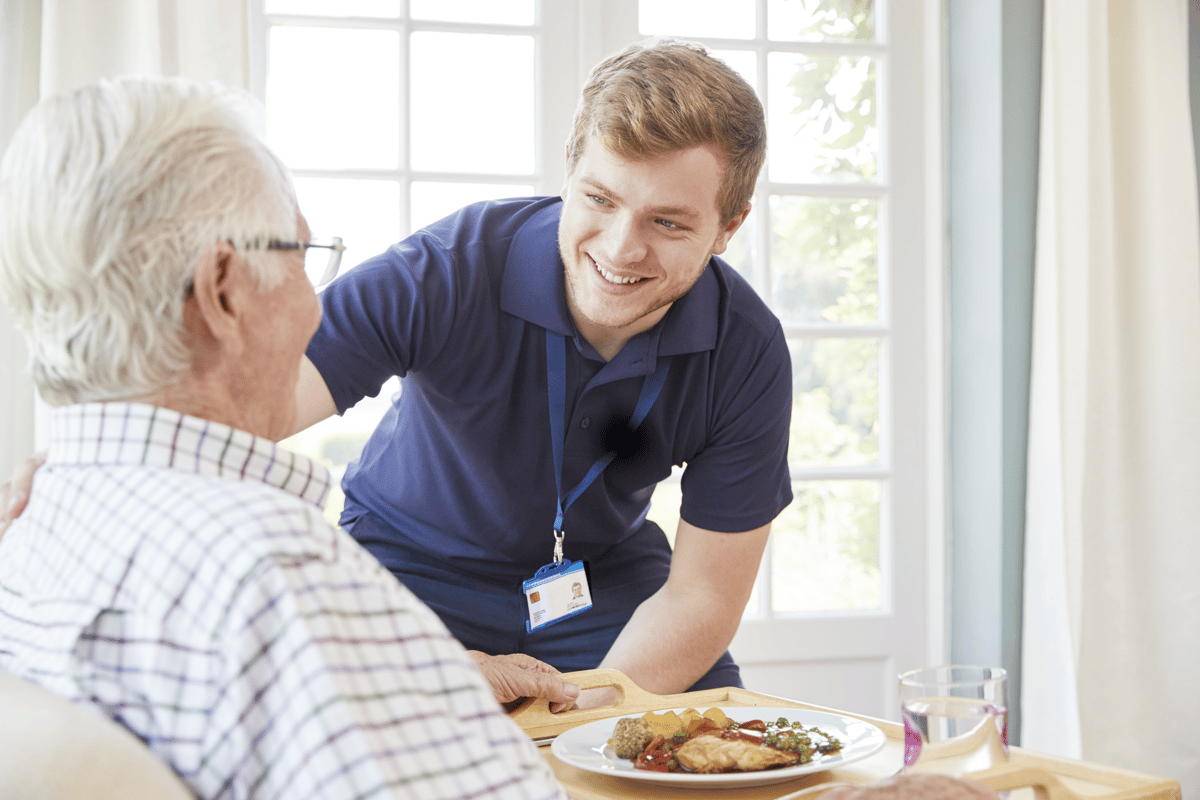 Care staff serving a meal to a resident