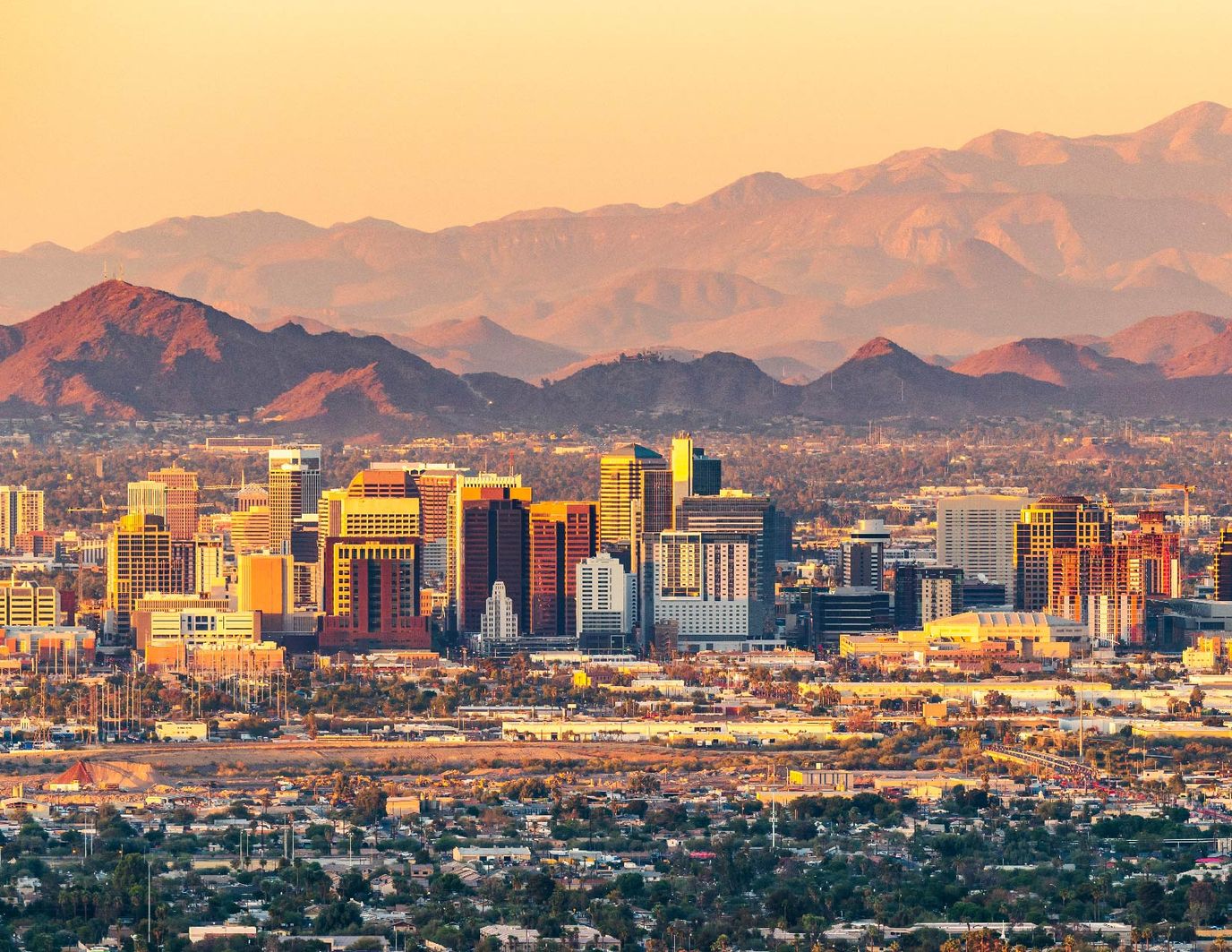 City skyline with mountains at sunset