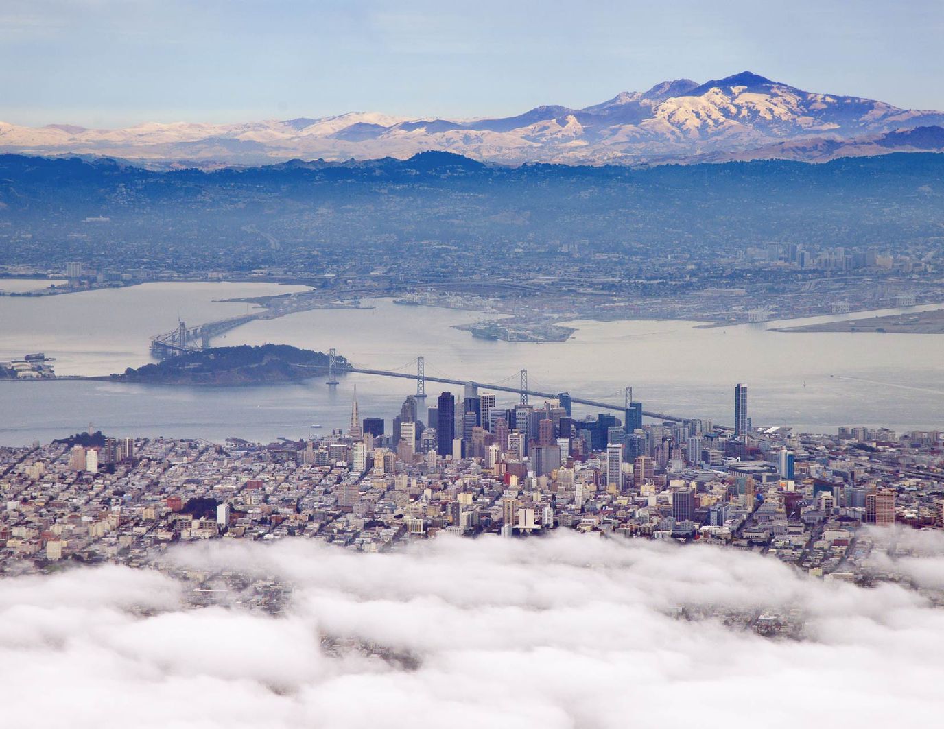 Aerial view of a city with mountains in the background.