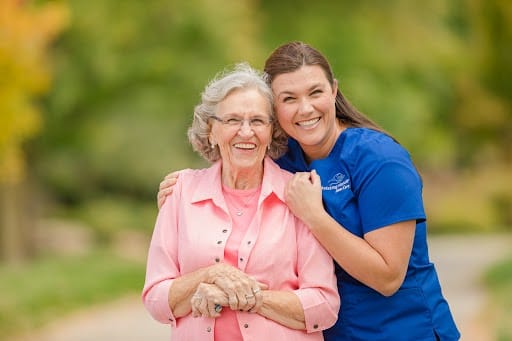 Staff member with resident outdoors, smiling