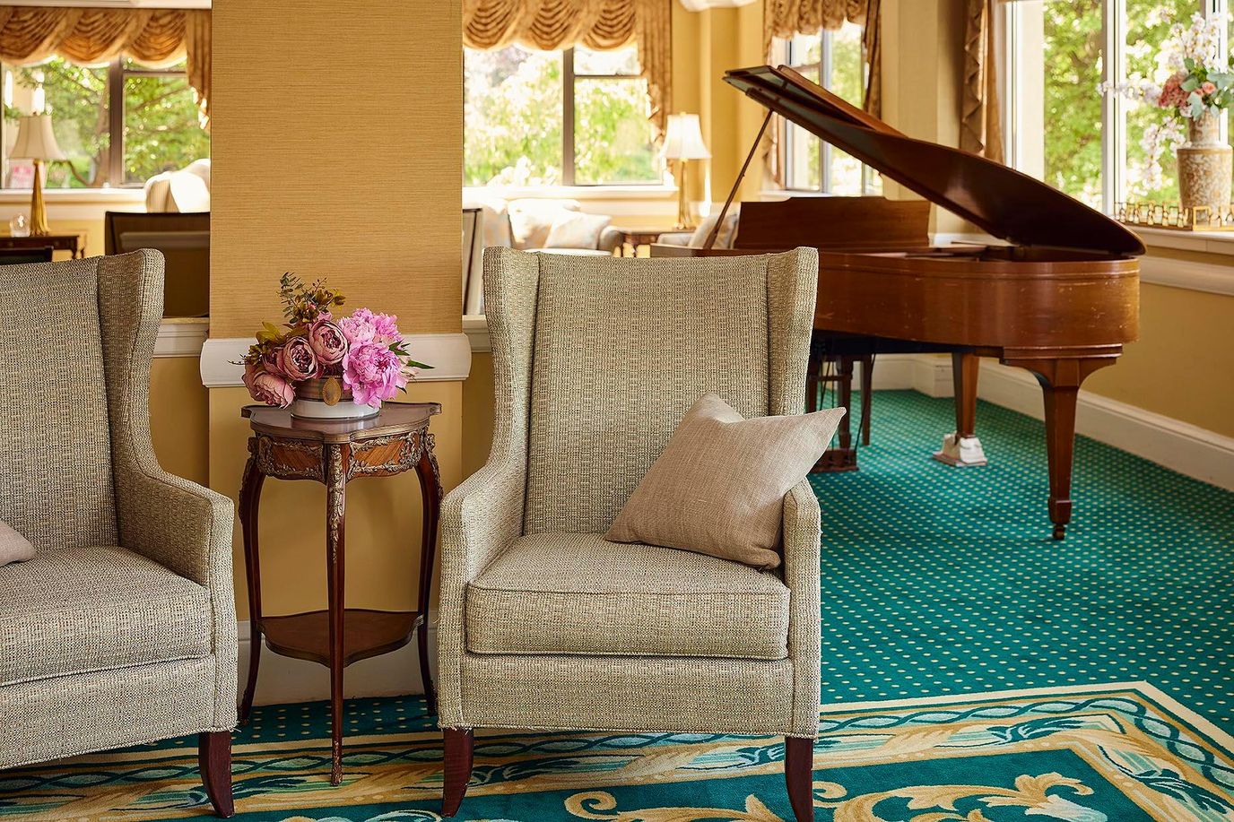 Cozy lounge area with two chairs and a piano