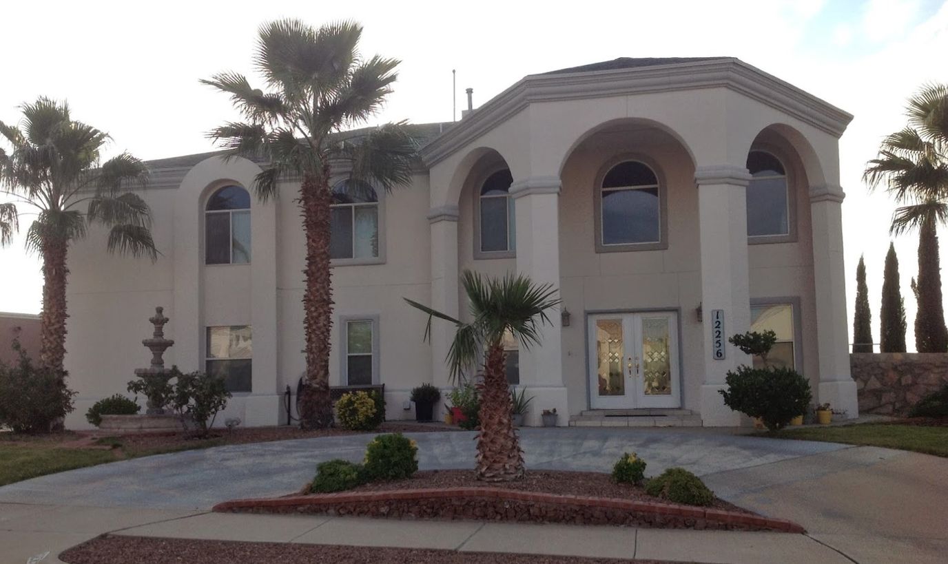 Exterior view of a senior living facility with palm trees