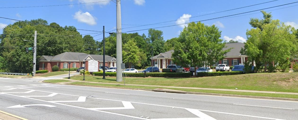 Street view of CenterWell Home Health building surrounded by trees and parking