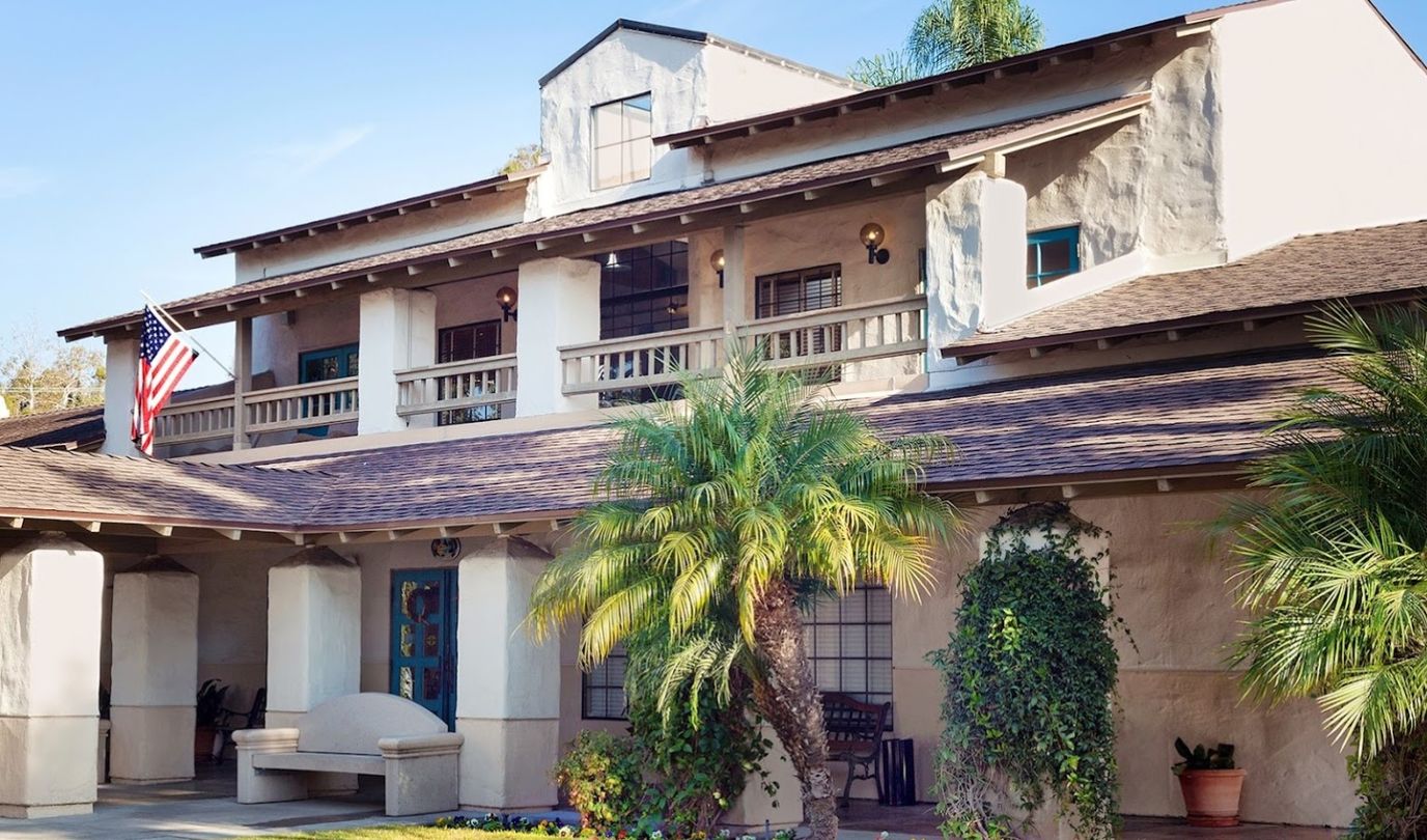 Exterior view of Ivy Park with palm trees and an American flag