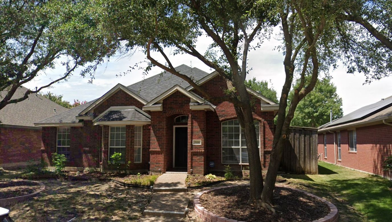 Exterior view of a senior living facility with gardens