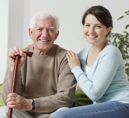 All the Comfort of Home Incorporated, home care in Denver, CO — Smiling senior man and caregiver in cozy living room