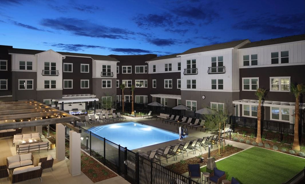 A well-lit outdoor space with a pool and seating areas
