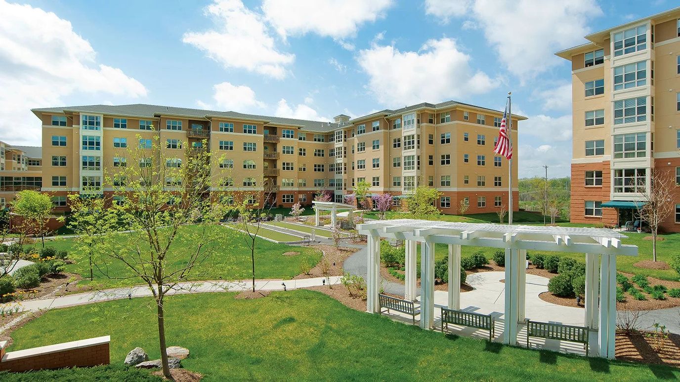 Exterior view of a senior living community with landscaped gardens