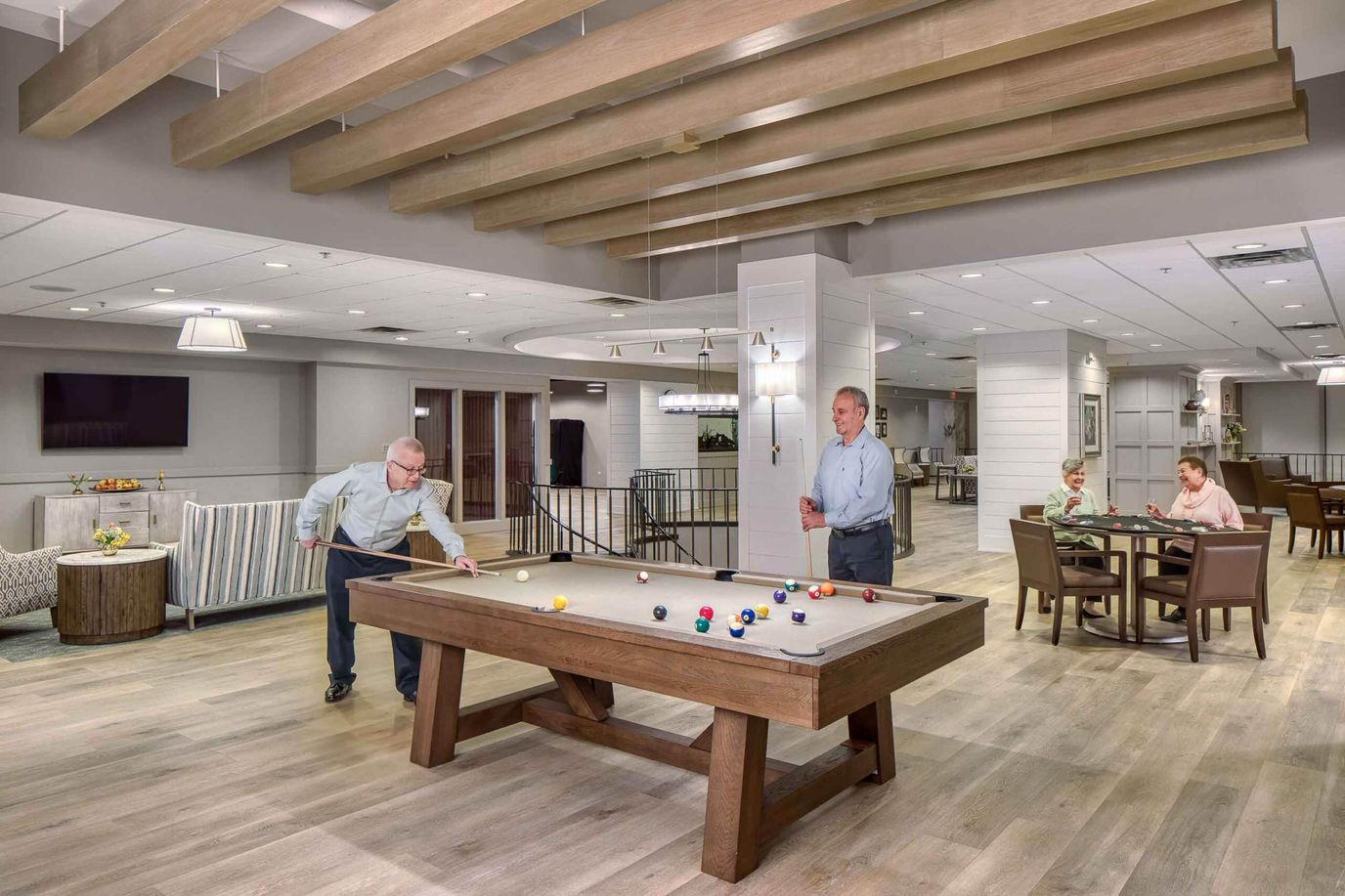 Residents enjoying a game of billiards in a common area.