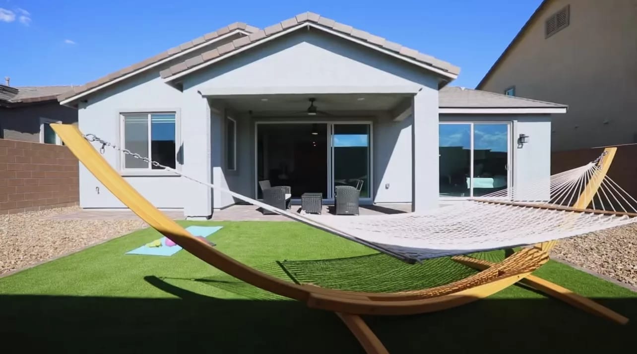 Exterior view of Serenity Manor with outdoor space and hammock