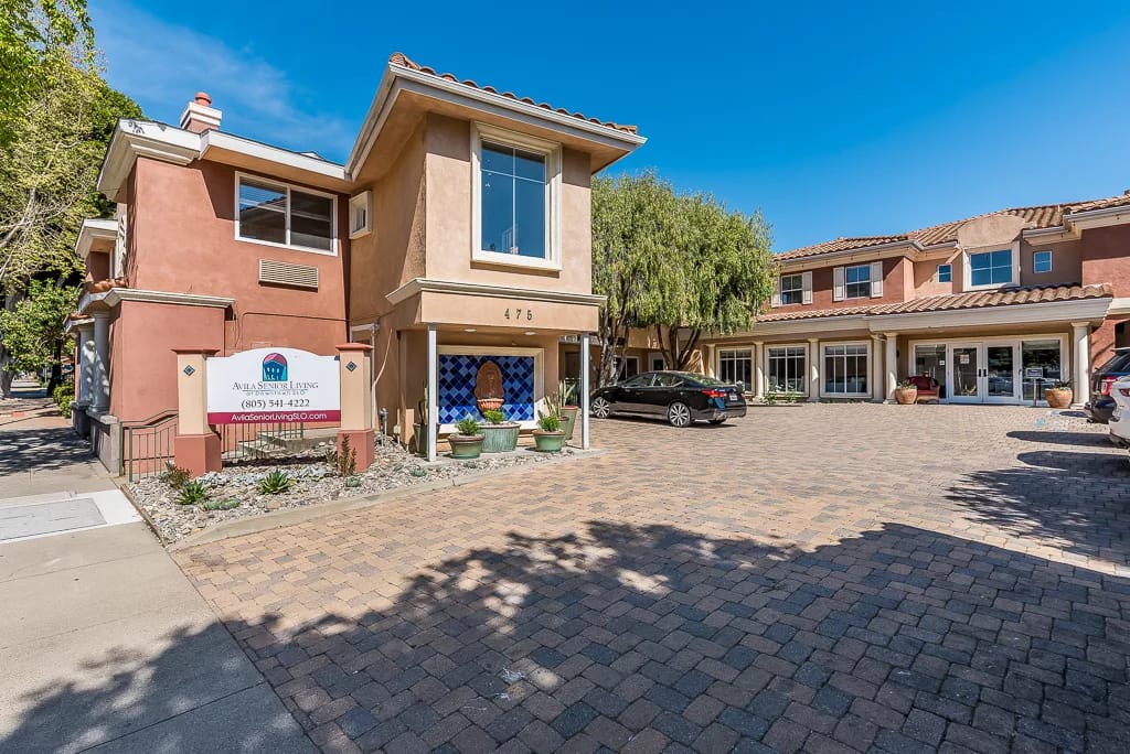 Exterior view of a senior living facility with parking area