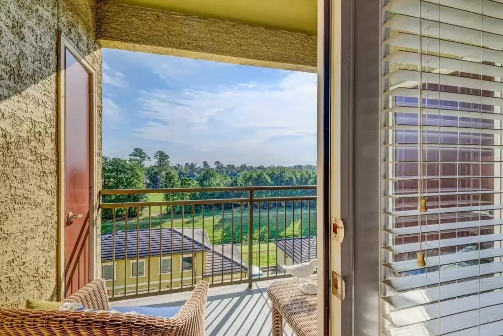 Conservatory at Champion Forest, independent living in Spring, TX — Balcony view of a scenic outdoor landscape