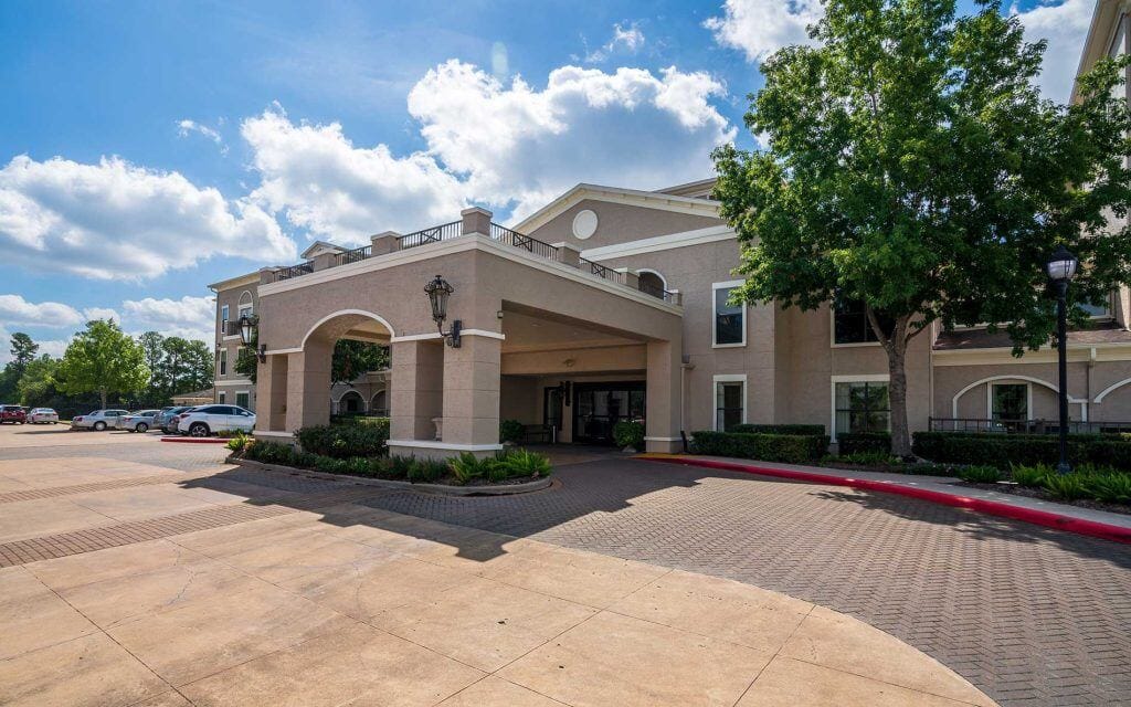 Conservatory at Champion Forest, independent living in Spring, TX — Entrance to a senior living facility with landscaping
