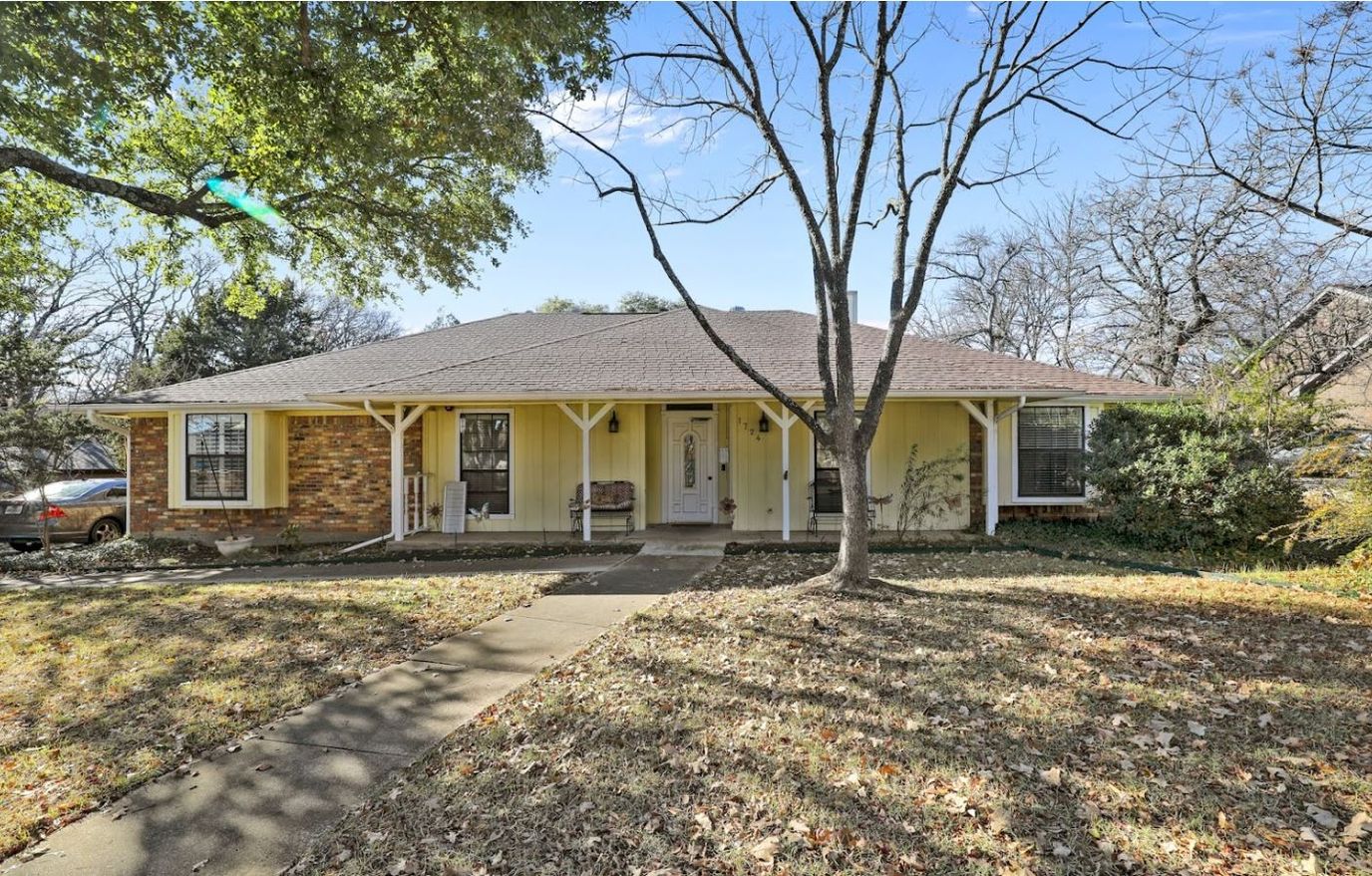 Exterior view of a yellow house with a porch